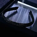 Close-up of luxury thin black headband featuring dense shimmering rhinestones in detail - Black