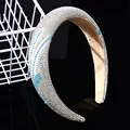 Primer plano de brillantes diamantes de imitación plateados y azules en una diadema ancha - 3cm / Azul lago