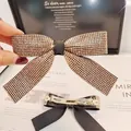 Détail d'une barrette à cheveux nœud avec strass dorés et pince à ressort de haute qualité - Style Zircon Champagne