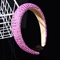 Primer plano de diadema acolchada con cristales rosas sobre una superficie negra brillante - Estilo Rectangular Cruzado de 3cm / Rosa