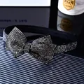 Makroaufnahme eines französischen Vintage-Haarreifs mit Strass-Schleife auf Stoff - Mineralgrauer Strass