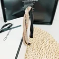 Detalle de elegante diadema de oro champán con estructura cruzada y pedrería brillante - Diamante Champaña