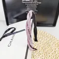Détail d'un serre-tête élégant aux strass roses avec un design torsadé raffiné - Rose