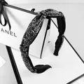 Dettaglio del cerchietto nero scintillante con strass e un elegante nodo centrale - Strass Grigio Minerale