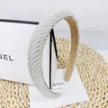 Detail eines eleganten Haarreif mit Perlen und Strass auf gewebtem Hintergrundtextur - Weißer Zirkon