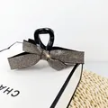 Elegant black bow hair claw clip with sparkling silver rhinestones and cross-bite grip - Transparent Grey Rhinestone