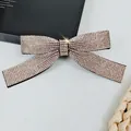 Close-up of a sparkling champagne crystal bow hair clip with luxury rhinestone inlay - Champagne