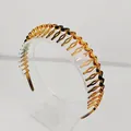 Dettaglio del cerchietto tartarugato ambrato con denti ondulati antiscivolo su base - Stile Dentato a Onde / Ambra