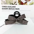 Primer plano de una pinza para el pelo negra con brillantes plateados sobre textura - Gris Transparente