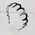 Dettaglio del cerchietto nero ondulato con finitura in resina lucida per lo styling capelli - Stile Nero con Denti Grandi / Nero