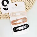 Three-piece set of oval hair clips in milk tea colors on white display card - Hollow Milk Tea Oval Style (NM-6621)