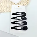 Detailansicht von vier mattschwarzen Metall-Haarspangen auf einer weißen Displaykarte - Mattierter Wassertropfen-Stil / Schwarz