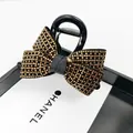 Makro-Detail einer schwarzen Haarklammer mit Schleife und Champagner-Strasssteinen - Medium Haarklammer / Teefarbener Strass