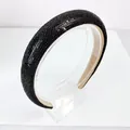 Close-up of padded black headband with dense shimmering rhinestones and textured finish - 2.5cm High Top / Black Zircon