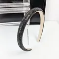 Gros plan sur un serre-tête en strass noirs avec une doublure intérieure en velours beige - Noir