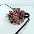 Détail d'une pince à cheveux à motif floral sertie de strass colorés étincelants - Coloré