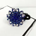 Close-up of sparkling rhinestone flower hair claw clip with elegant blue and white crystals - Blue