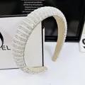 Elegant wide padded headband with sparkling rhinestones and pearls for a luxury look - Straight Style / 2.5cm / White Zircon / [product Attributes] This Product Is A Wide-brimmed Thick Headband. Visually It Appears To Be Made Of Off-white Fabric With A Densely Stitched Surface Inlaid With Numerous Small Rhinestones And Semi-circular Artificial Pearls Presenting A Shimmering Silver-white Texture. The Style Leans Towards A Luxurious High-society Look Suitable For Formal Occasions Such As Weddings And Parties. [visual Presentation] The Image Is A Close-up Shot With The Headband Positioned Diagonally In The Center Of The Frame Creating A Full And Prominent Subject. The Background Uses A Minimalist Black And White Brand Paper Bag (partially Visible) And A Decorative Frame With English Lettering Achieving A Highly Harmonious Color Scheme. Image Quality Is [high] With Sharp Details And A Strong Sheen. Aesthetic Appeal Is [high] With An Overall Score Of [8.5]. The Prop And Product Category Are Well-matched Successfully Highlighting The Product's High-end Quality. [text Content] The Text Includes The "el" On The Background Paper Bag And The English Decorative Text Above It All Categorized Under Prop_text Which Is Part Of The Prop And Does Not Affect Cross-border Sales. [logistics Labels] None. [infringement Risk] Product Infringement: None; Background Infringement: Suspected Chanel-background Paper Bag-logo (only El Is Displayed) Although It Contains Brand Elements It Is Not The Product Itself. Probability Of Infringement [0.1]. 【product Parameters】wide Border Design Fully Handmade Inlay Style.