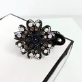 Detailed macro shot of floral hair claw clip featuring sparkling crystals and rhinestones - Gray