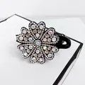 Macro detail of elegant hair claw clip featuring shimmering rhinestone flower pattern - White
