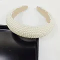 Gros plan de perles blanches et doublure en tissu beige antidérapant sur le bandeau - Grille complète en perles d'imitation