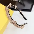 Close-up of black headband with champagne gold rhinestones and twisted knot design - Champagne Rhinestone