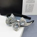 Detalle de diamantes de imitación brillantes en una diadema elegante con lazo - Circonio AB