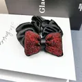 Nahaufnahme einer Satin-Haarklammer mit roten Strasssteinen auf einer Geschenkbox - Voll Strass Blase Kissen Scrunchie (Ankara Rot)
