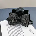 Dettaglio macro di strass scintillanti sulla molletta a fiocco nero con velluto - Pinza per capelli / Strass Nero Fucile