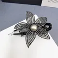Dettaglio del fermaglio a fiore con strass scuri e una grande perla grigia centrale - Strass Grigio Minerale