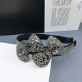 Primer plano de la diadema de lazo negro con cristales plateados brillantes incrustados - Diamante de imitación gris transparente