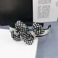 Detailed view of wide black headband with crystal encrusted bow and sparkling rhinestones - White Glass Black Rhinestone