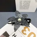 Dettaglio della pinza per capelli a fiore in rete con strass scuri e perla centrale - Strass Blu Navy