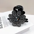 Close-up of elegant black floral hair claw clip with sparkling grey crystal rhinestones - Flower Large Rhinestone Medium Hair Claw / Transparent Grey Rhinestone