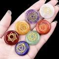 Polished 7 chakra natural stone set with engraved gold symbols held in hand - Chakra Energy Stone Round Discs (549-1)