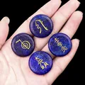 Deep blue Lapis Lazuli Reiki stones with gold engraved symbols held in palm - Lapis Lazuli