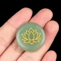 Green aventurine crystal energy stone with golden lotus engraving held in hand - Green Aventurine