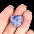 Polished heart-shaped blue sodalite natural stone small ornament held by fingers - Blue Spot Jasper