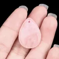 Handheld view of a polished teardrop pink quartz pendant for DIY jewelry design - Rose Quartz