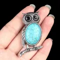 Vintage silver owl necklace with large turquoise stone held in hand for size reference - Blue Turquoise (Synthetic)