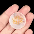 Polished round pink quartz crystal with golden lotus engraving held in hand - White Crystal
