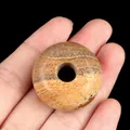 Natural Picture Jasper stone 30mm donut bead with brown wood grain texture in hand - Jasper
