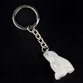 Llavero de pájaro tallado en piedra blanca con anillo plateado sobre fondo negro mate - Estilo Rana (5468999897024) / Cristal de roca