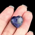 Polished heart-shaped natural blue sodalite stone held by hand for decoration - Sodalite
