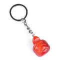 Translucent red carnelian turtle keychain pendant with silver metal ring on white background - Red Agate