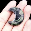 Pierre de lune en jaspe Kambaba poli tenu à la main aux reflets verts - Rhyolite