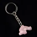 Pink dolphin gemstone keychain with silver metal ring on a textured black surface - Rose Quartz