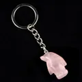 Porte-clés pingouin en quartz rose avec anneau en métal argenté sur fond noir - Quartz rose