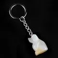 White opal dog charm keychain with silver metal ring on a sleek black background - Natural Agate