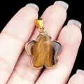 Tiger eye stone carved five-petal flower pendant with gold plated edges on hand - Tiger's Eye